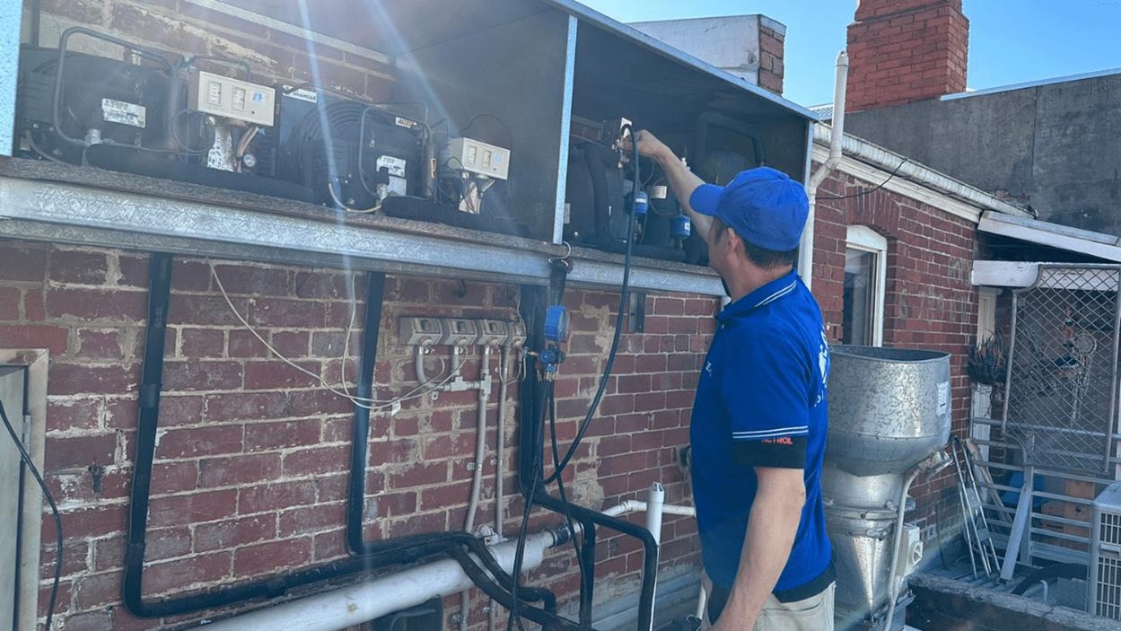 Technician fixing commercial fridge