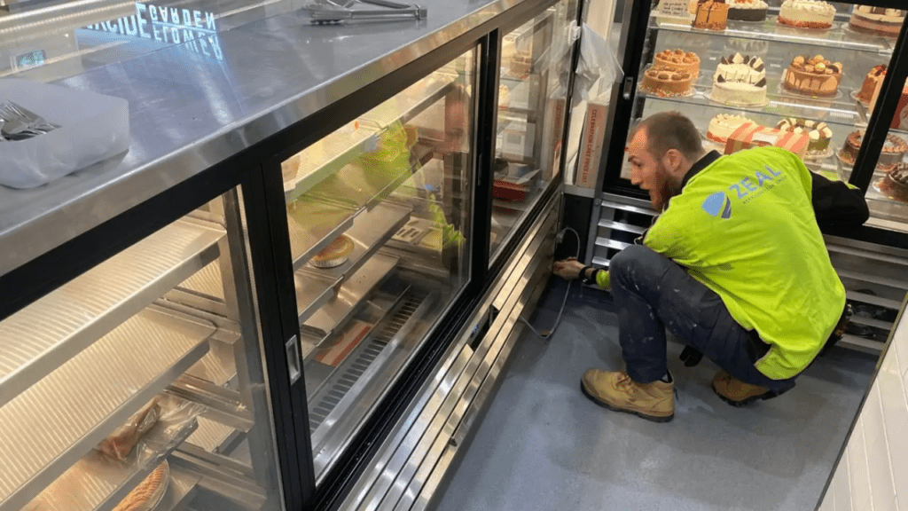 Technician repairing commercial refrigerator